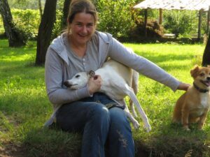 Maria głaszcze rudąTinkę, a Kubi whippet próbuje się przytulić całym sobą.